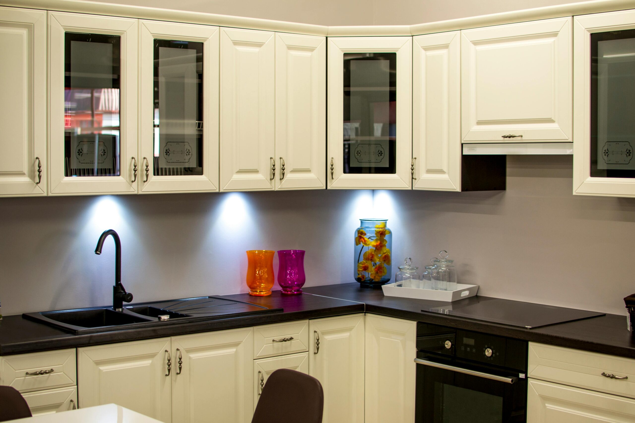 Beautifully finished cabinets by Luxury Dallas Painters, A stylish modern kitchen with white cabinets and colorful decor pieces.